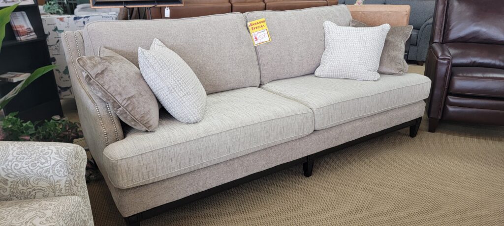 Light beige Decor-Rest sofa with nailhead trim and coordinating pillows, marked as a manager special.