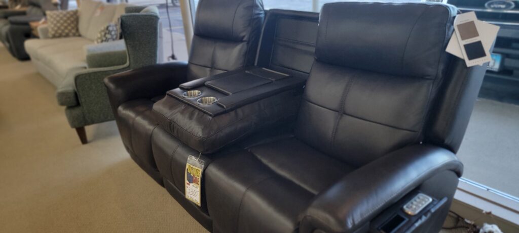 Black leather power reclining loveseat with center console on the showroom floor at Meyers Furniture in Rochelle IL
