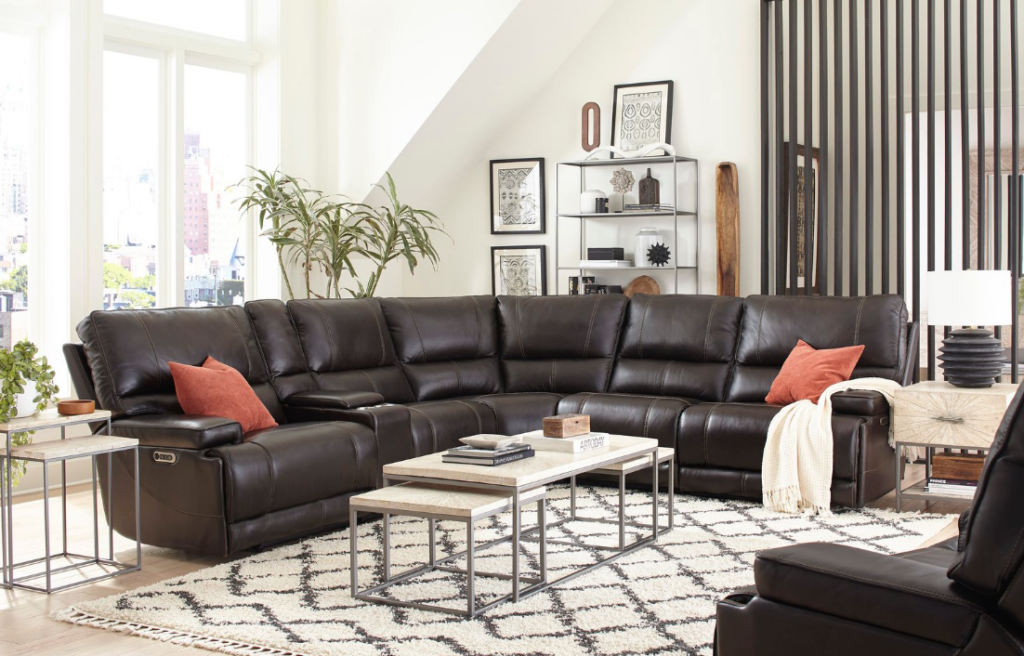 Dark leather Parker House 6-piece reclining sectional styled in a bright living room with accent pillows and modern tables.