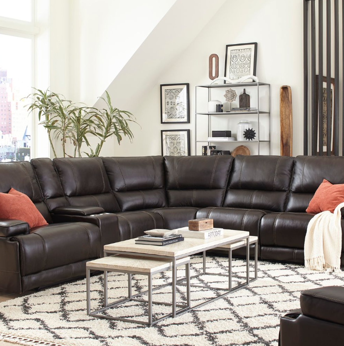 Dark leather Parker House 6-piece reclining sectional styled in a bright living room with accent pillows and modern tables.