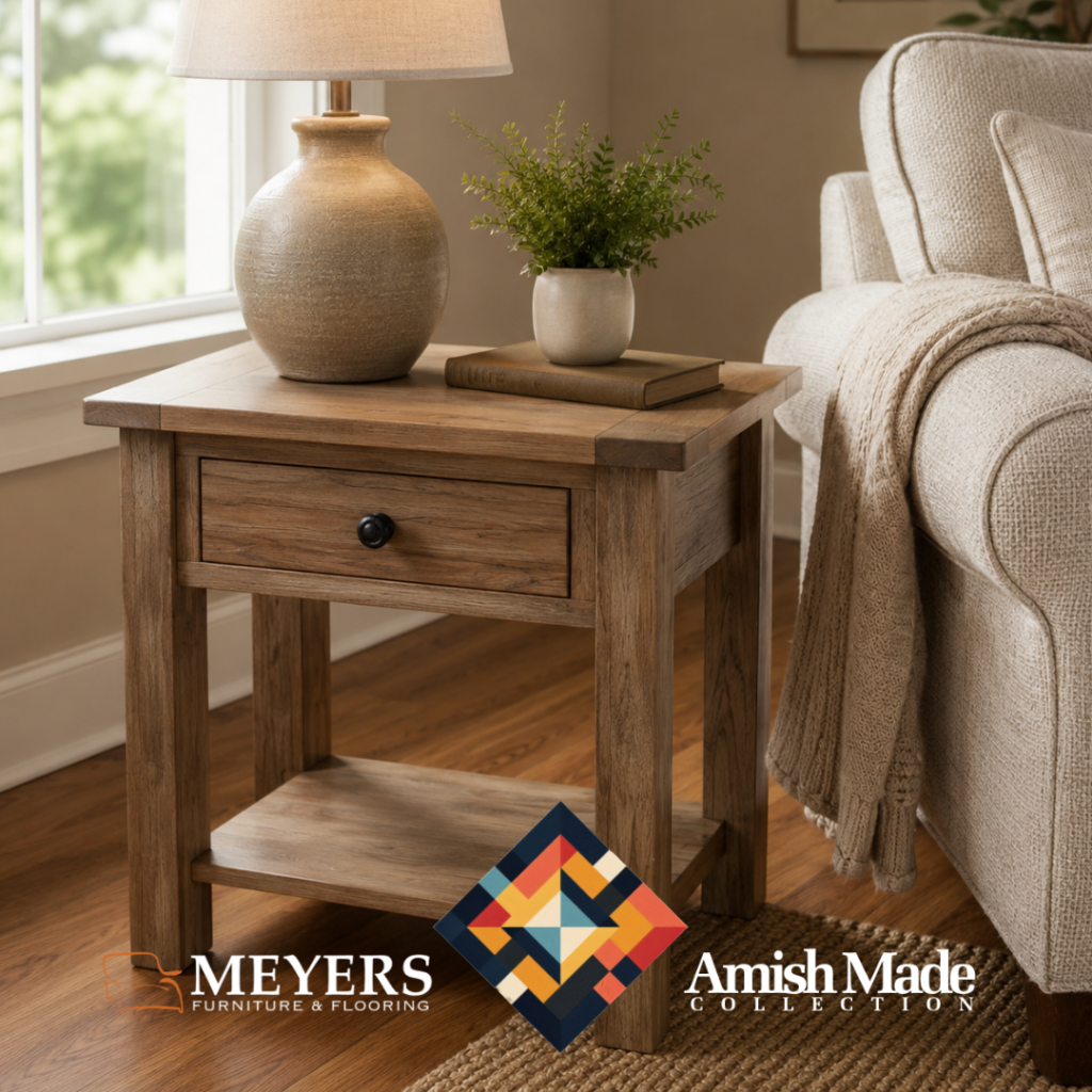 Amish-made wood side table with drawer and lower shelf beside a neutral sofa